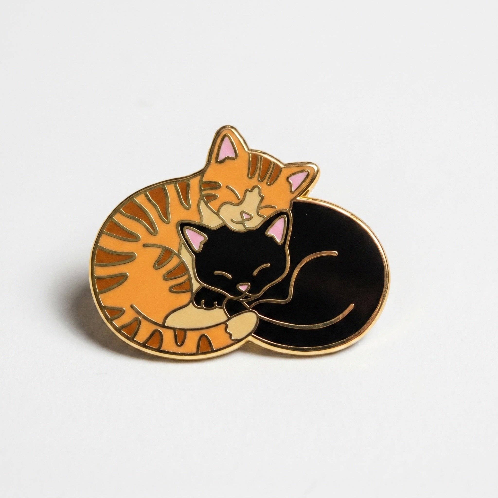 Cuddle Cats hard enamel pin: sleeping orange tabby and black cat with a deluxe clasp.