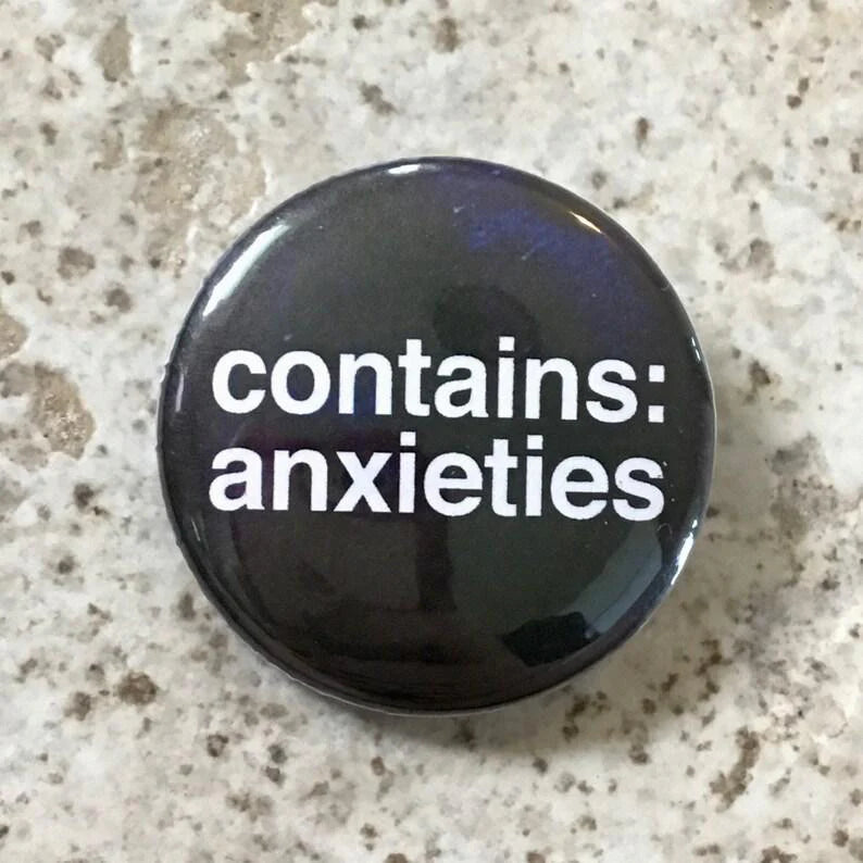 Contains Anxieties button pin, 1.25 inches, featuring white text on a speckled background.