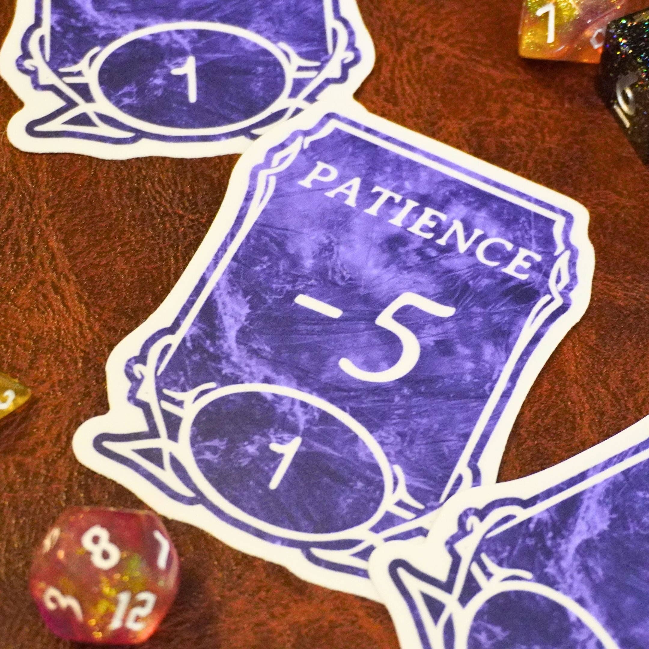 Patience -5 Sticker displayed with colorful polyhedral D&D dice; sticker design is weatherproof.