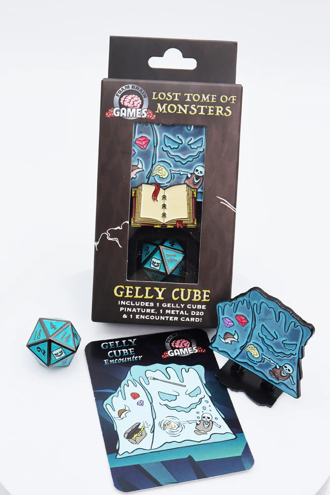 Lost Tome of Monsters Gelly Cube set with blue D20 die, miniature pin, and illustrated encounter card.