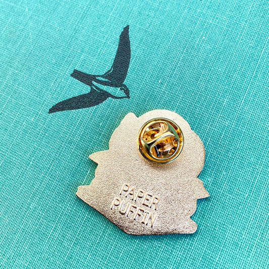 Back of Book Stacks Cat enamel pin with gold-toned metal, butterfly clutch, and embossed PAPER PUFFIN text.