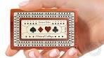 Cribbage Pocket Travel game board with spade, diamond, heart, and club symbols on the lid held in a hand.