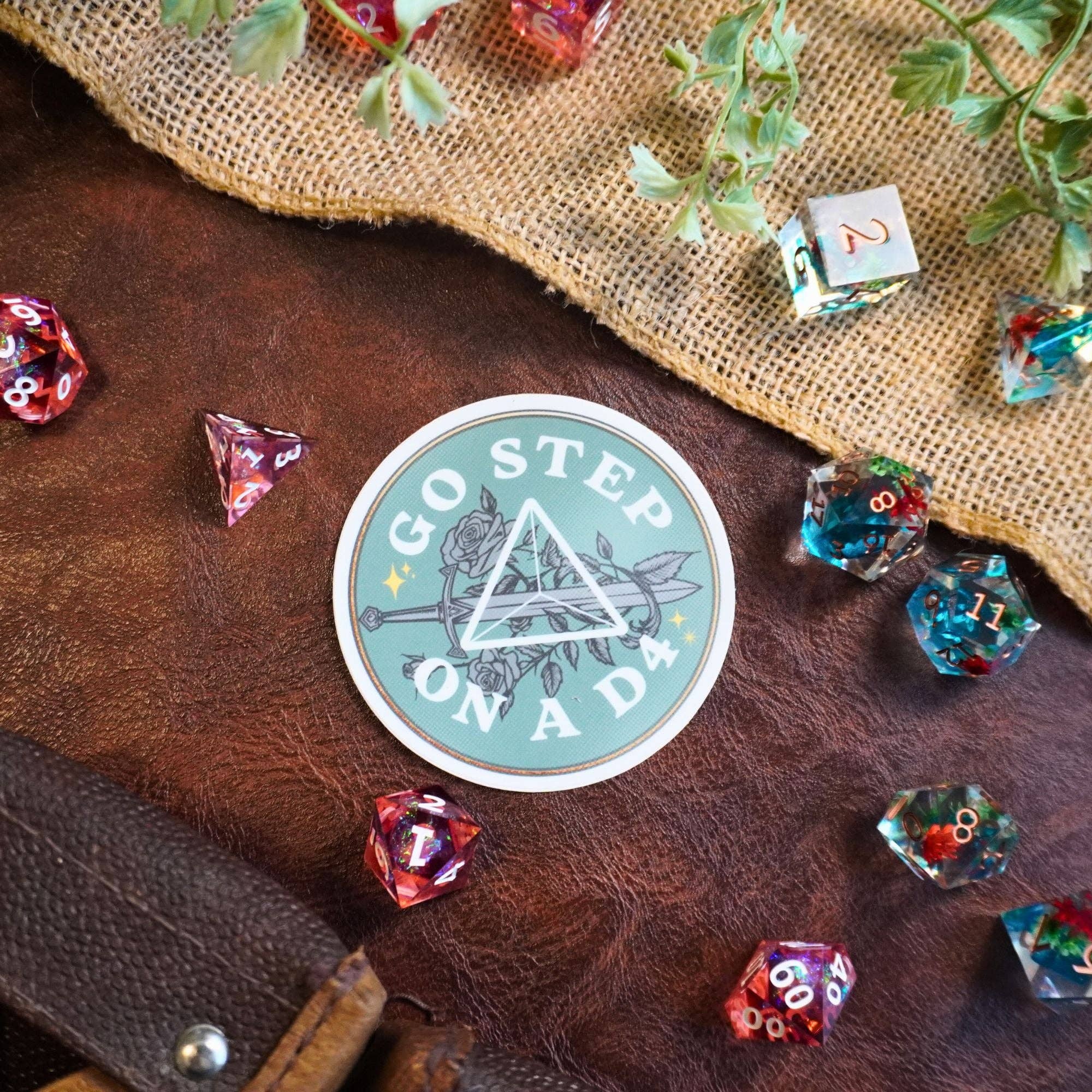 Round Go Step on a D4 sticker featuring polyhedral dice and greenery.