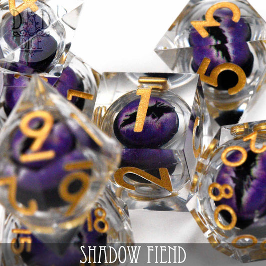 Shadow Fiend - Liquid Core resin dice with clear casing, gold numbers, black-purple swirls, and bottom label.