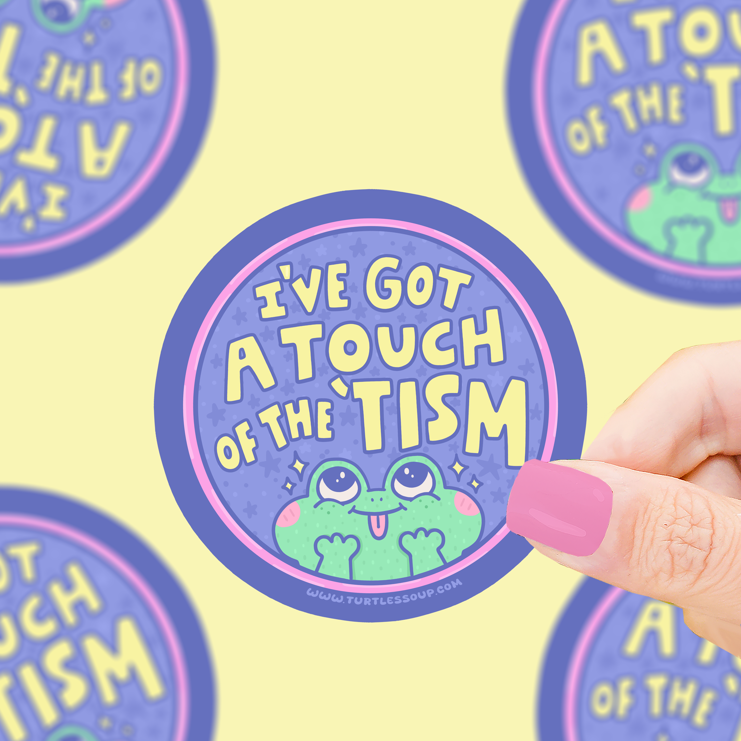 Touch of the ‘Tism Frog Autism Awareness vinyl sticker held in a hand.