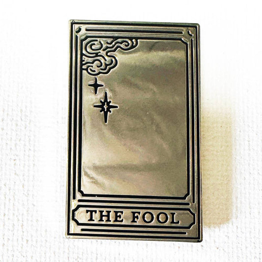 The Fool Mirror tarot card pin: a rectangular, silver-plated hard enamel pin with corner scrolls and THE FOOL text.
