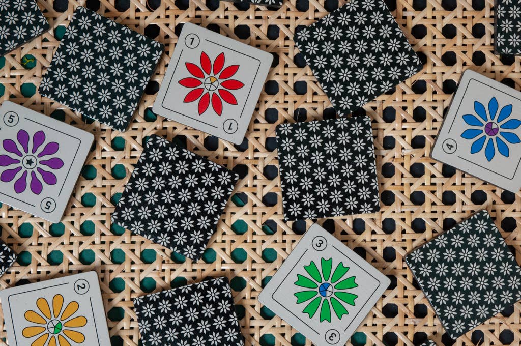 Kuzus Maze flower-themed cards, face down, displayed on a woven surface.