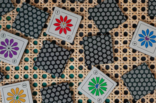 Kuzus Maze flower-themed cards, face down, displayed on a woven surface.