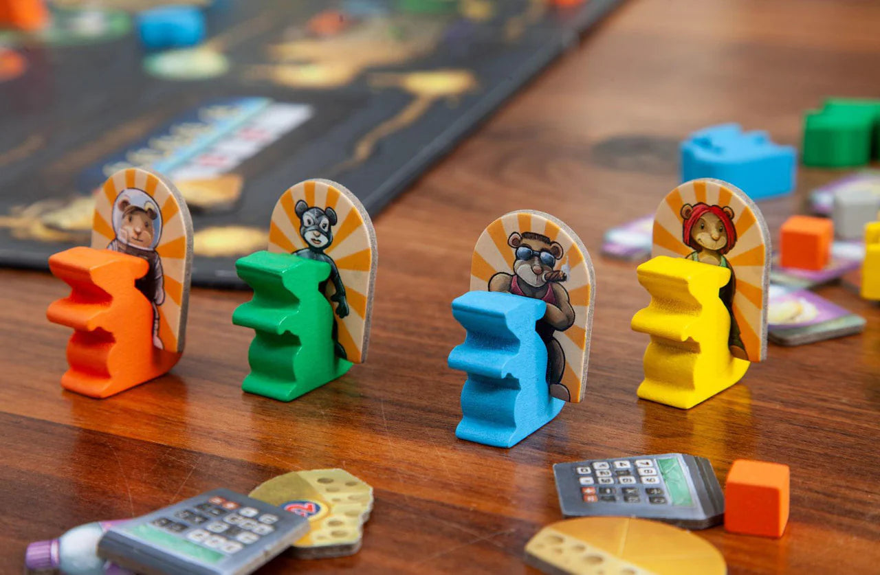 First Rat board game with four colorful animal pieces, cards, and scattered tokens displayed on a wooden table.