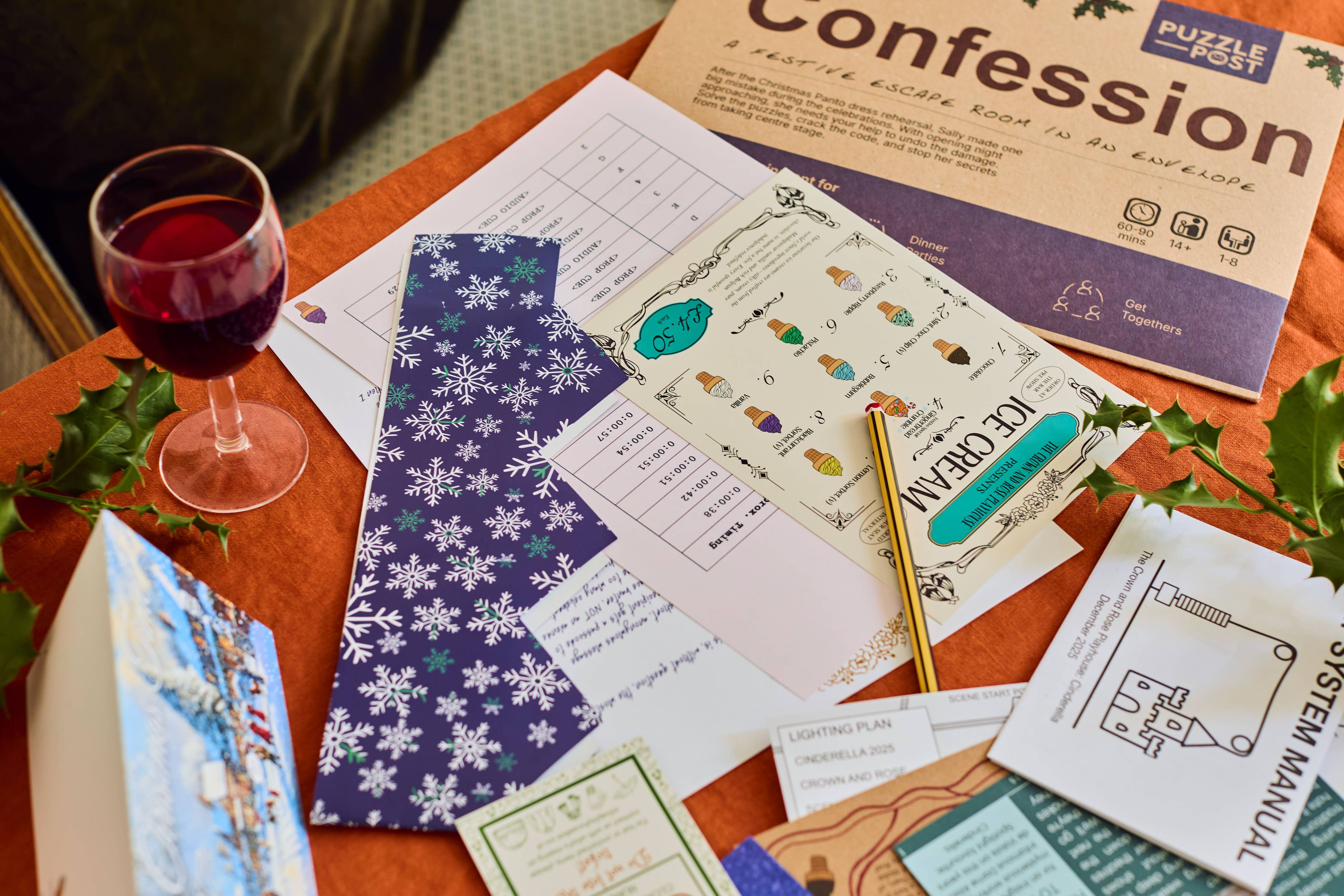 The Confession Escape Room Puzzle Board Game with puzzles, pen, drink, and holly leaves on a tabletop.