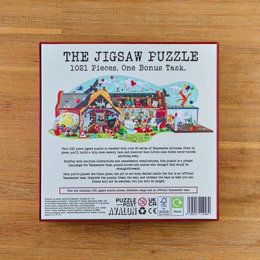 Taskmaster Jigsaw Puzzle, 1021 pieces, includes a secret task; box shows a colorful house illustration.