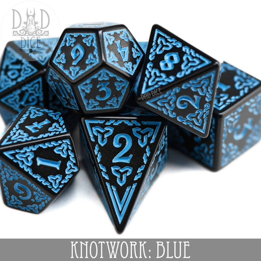The Knotwork: Blue set includes 7 black acrylic dice with blue knotwork designs, including a teardrop-shaped D4.