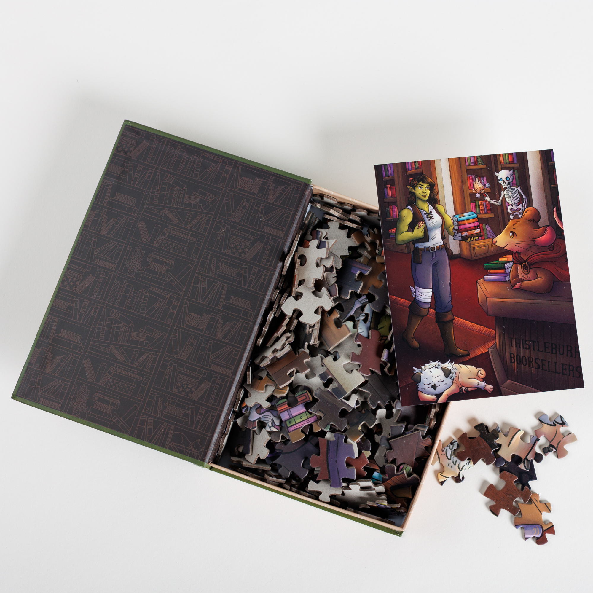 Thistleburr Bookshop Keepsake Puzzle | Bookshops & Bonedust, open with scattered pieces and a character card visible.