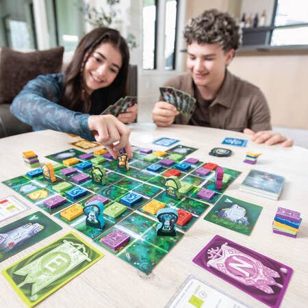 SEEKER OF SPELLS board game with cards, tiles, tokens, and spellbooks being played by two people.