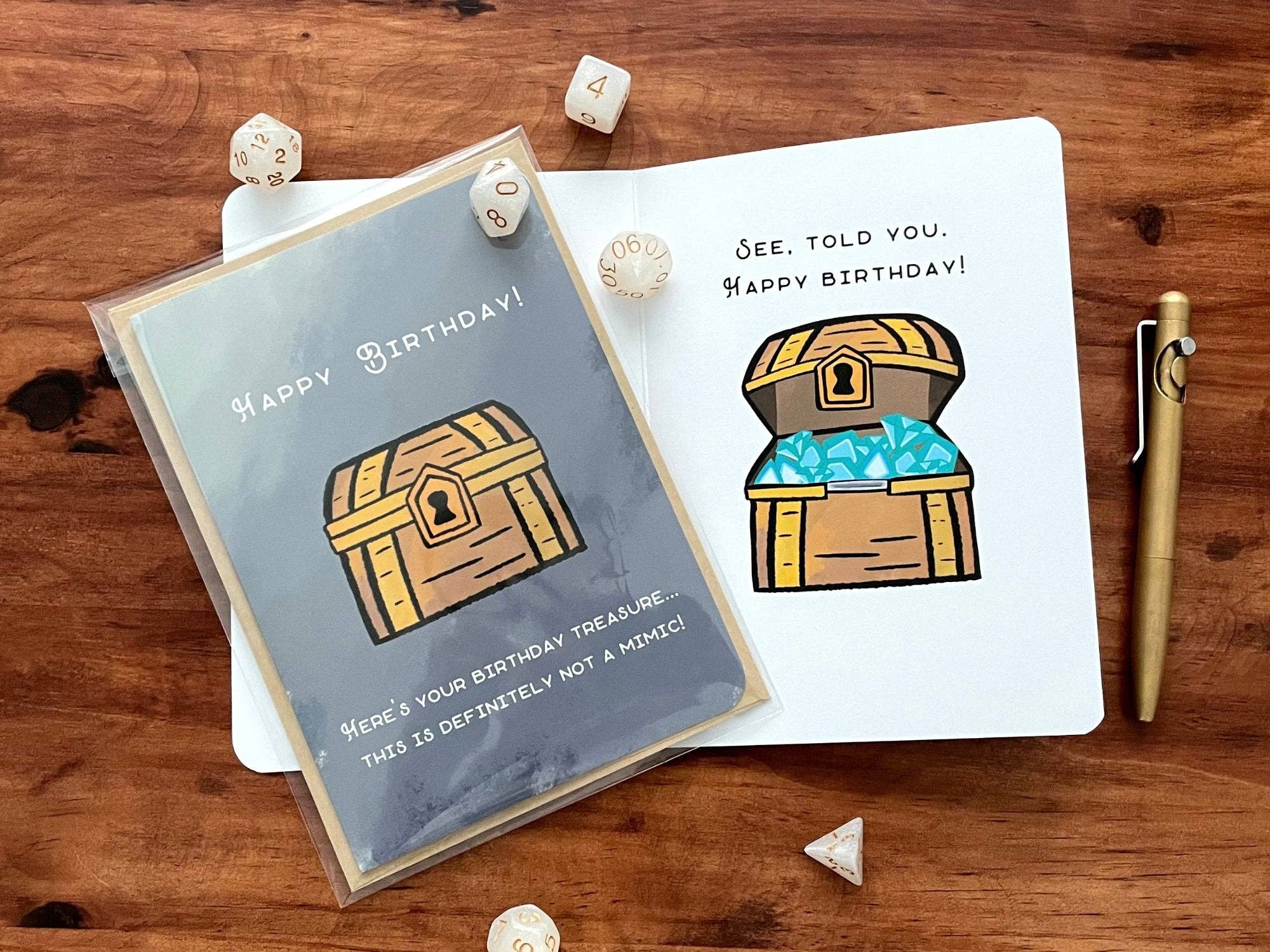 Not A Mimic Birthday Card with illustrations of a treasure chest, dice, and pen.