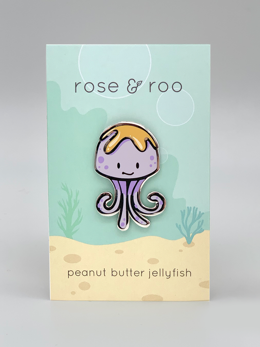 Peanut Butter Jellyfish Enamel Pin showing a jellyfish with peanut butter on its head.