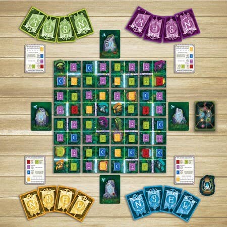 SEEKER OF SPELLS board game components including cards, player boards, and spellbooks arranged on a wooden table.