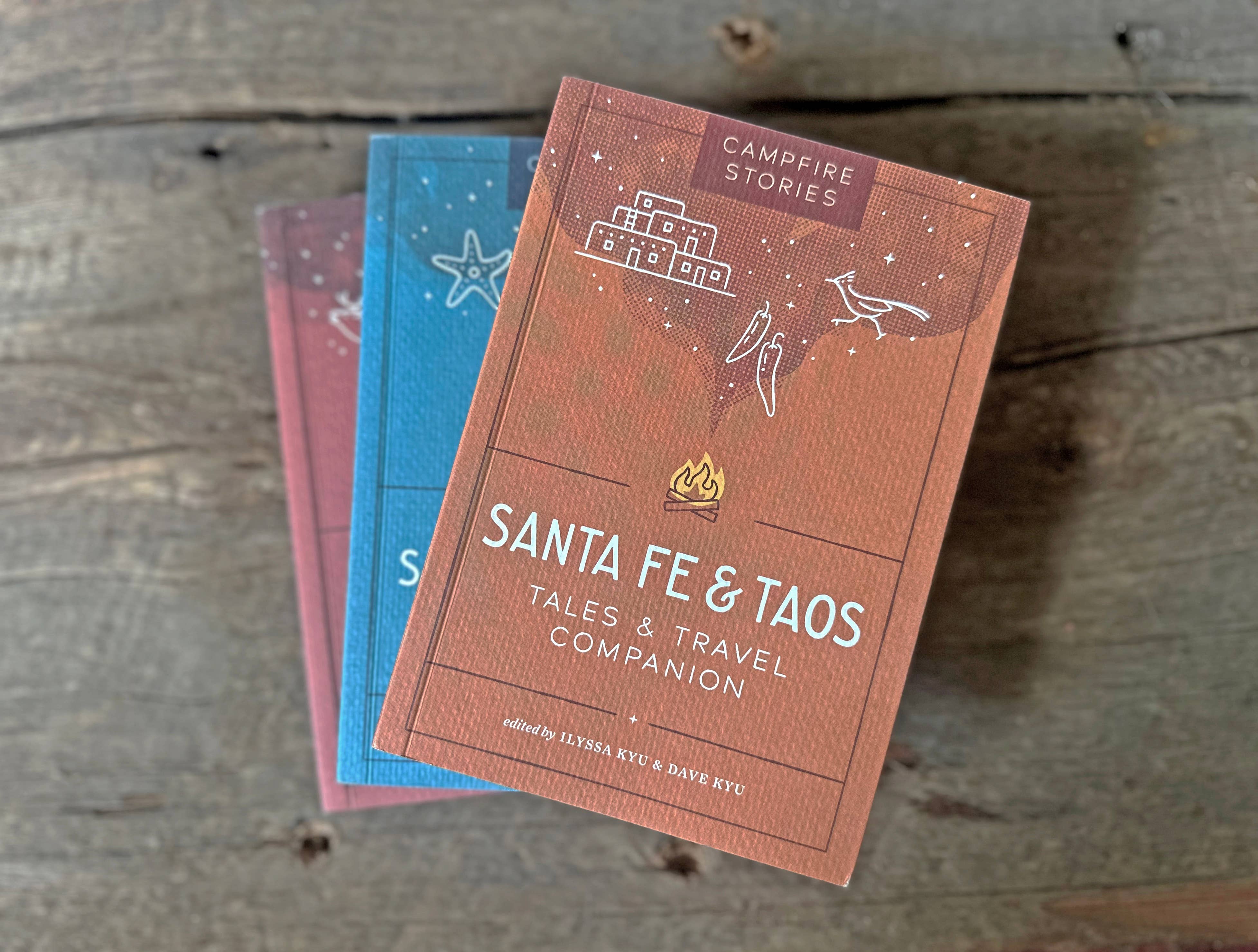 Campfire Stories: Santa Fe & Taos game displayed on top of two books on a wooden surface.