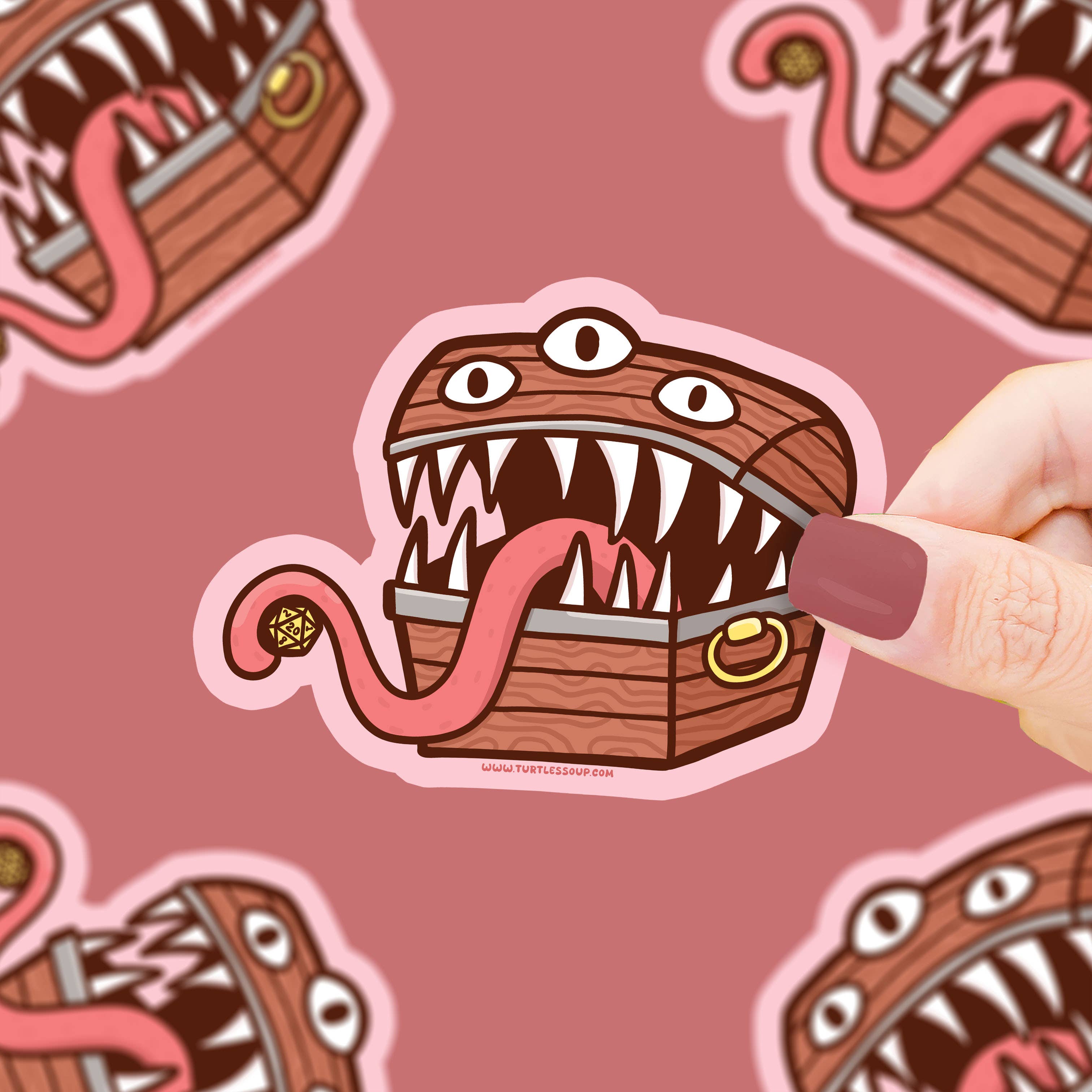Mimic Treasure Chest Vinyl Sticker with sharp teeth, three eyes, and a long tongue held in a hand.