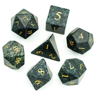 Algal Gemstone dice set with seven black and green marbled dice, gold engraving, on a white background.