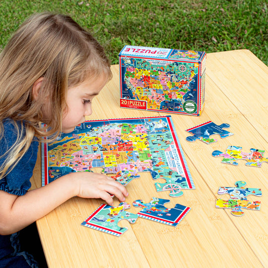 USA Map 20 Piece Puzzle with landmarks being assembled on a wooden table outdoors.