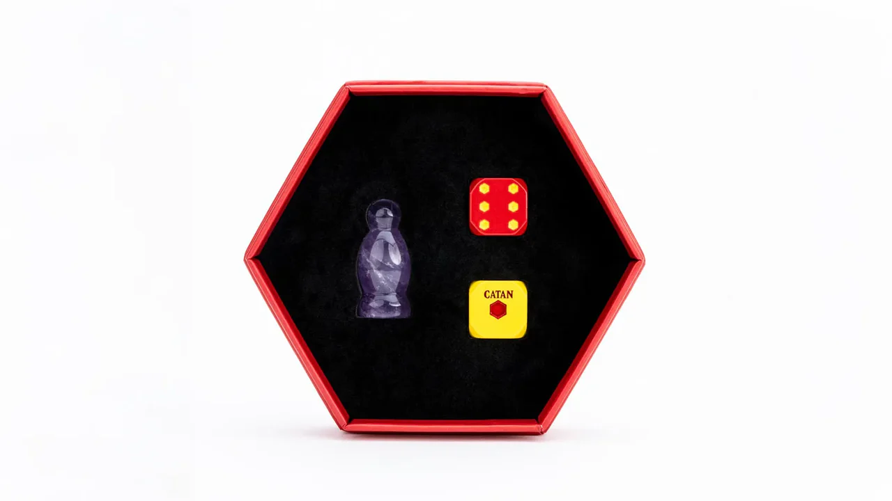GenCon Exclusive CATAN® Premium Robber & Metal Dice Set – Amethyst displayed in a hexagonal tray on a black surface.