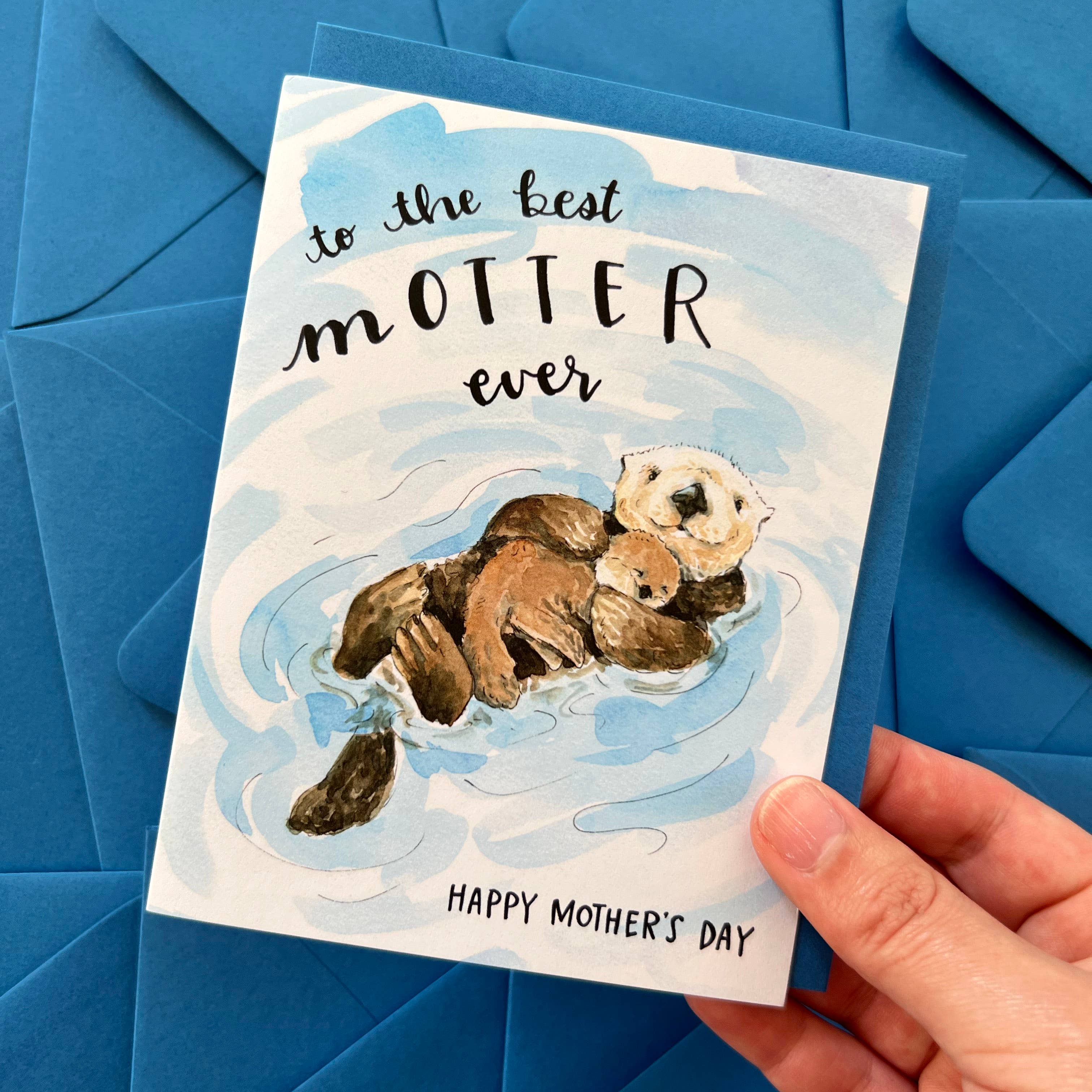To The Best Motter Ever Otter Mothers Day Card with cuddling otters and message, held in a hand.