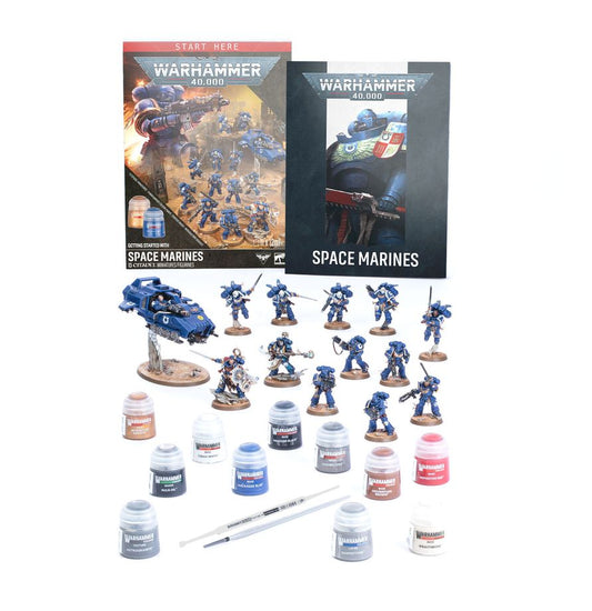 Warhammer 40,000 Space Marines starter kit with paints, brushes, assembled miniatures, and instructions.