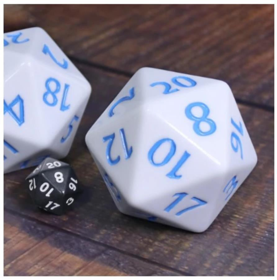 Two 55mm Titan D20 White with Blue dice next to a small black die on a wooden surface.