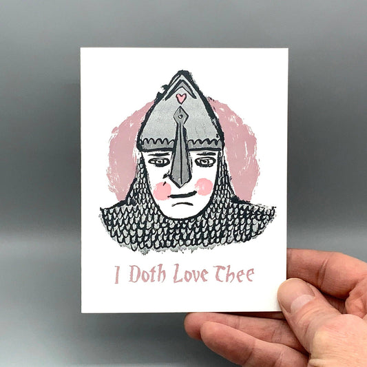 “I Doth Love Thee” cotton paper note card with blushing knight’s face letterpress design held by a hand.