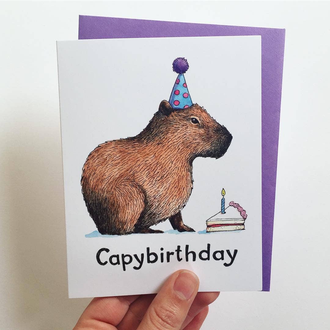 Birthday card featuring a watercolor capybara wearing a party hat, cake, and the text Capybirthday.