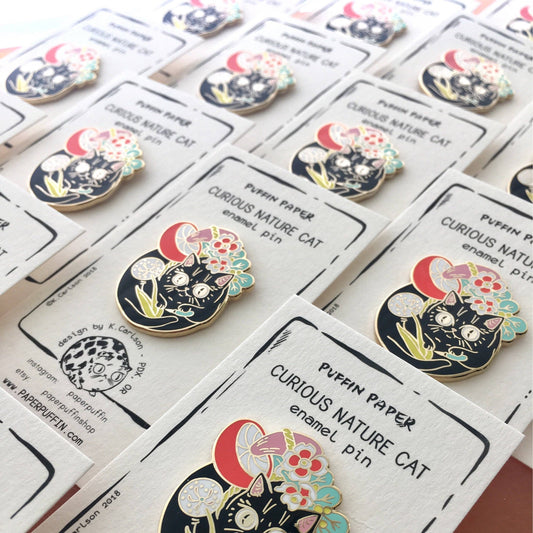 Curious Nature cat enamel pin with mushroom and floral design.