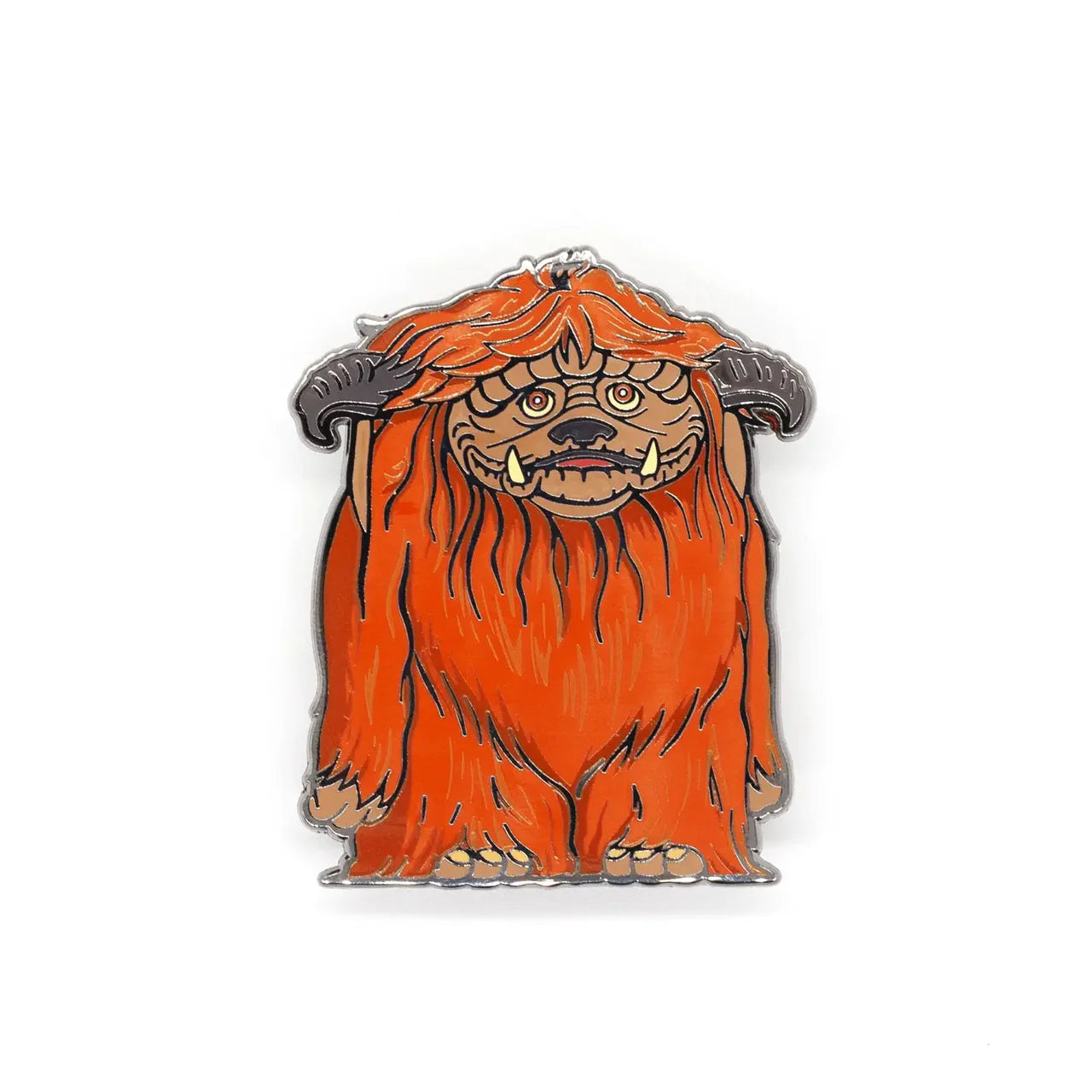 Ludo enamel pin featuring a cartoonish orange monster with long fur, horns, and sad eyes, inspired by Labyrinth.