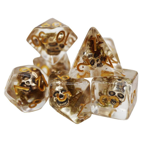 Silver Pirate Skull Dice: clear polyhedral dice with gold numbers and small skulls inside.