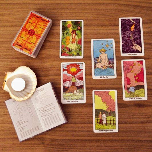 Cosmic Slumber Tarot Deck cards arranged with an open guidebook on a wooden table.