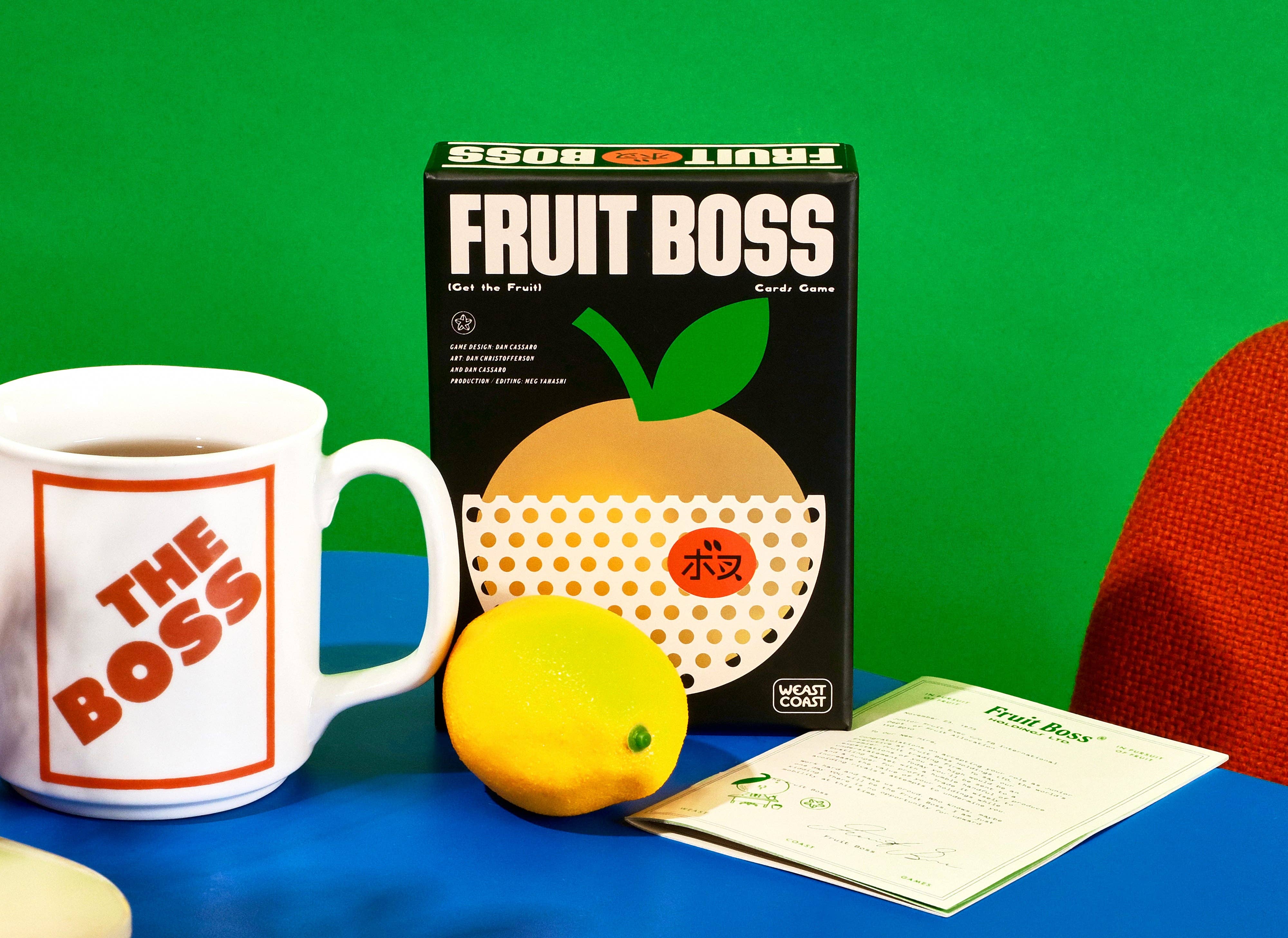 Fruit Boss cup, card game box, and papers displayed together.