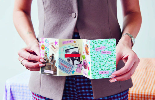 Person holding The Art of Memory Collecting handmade scrapbook for memory keepsakes.