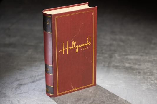 Hollywood 1947 vintage red book standing upright on gray surface.