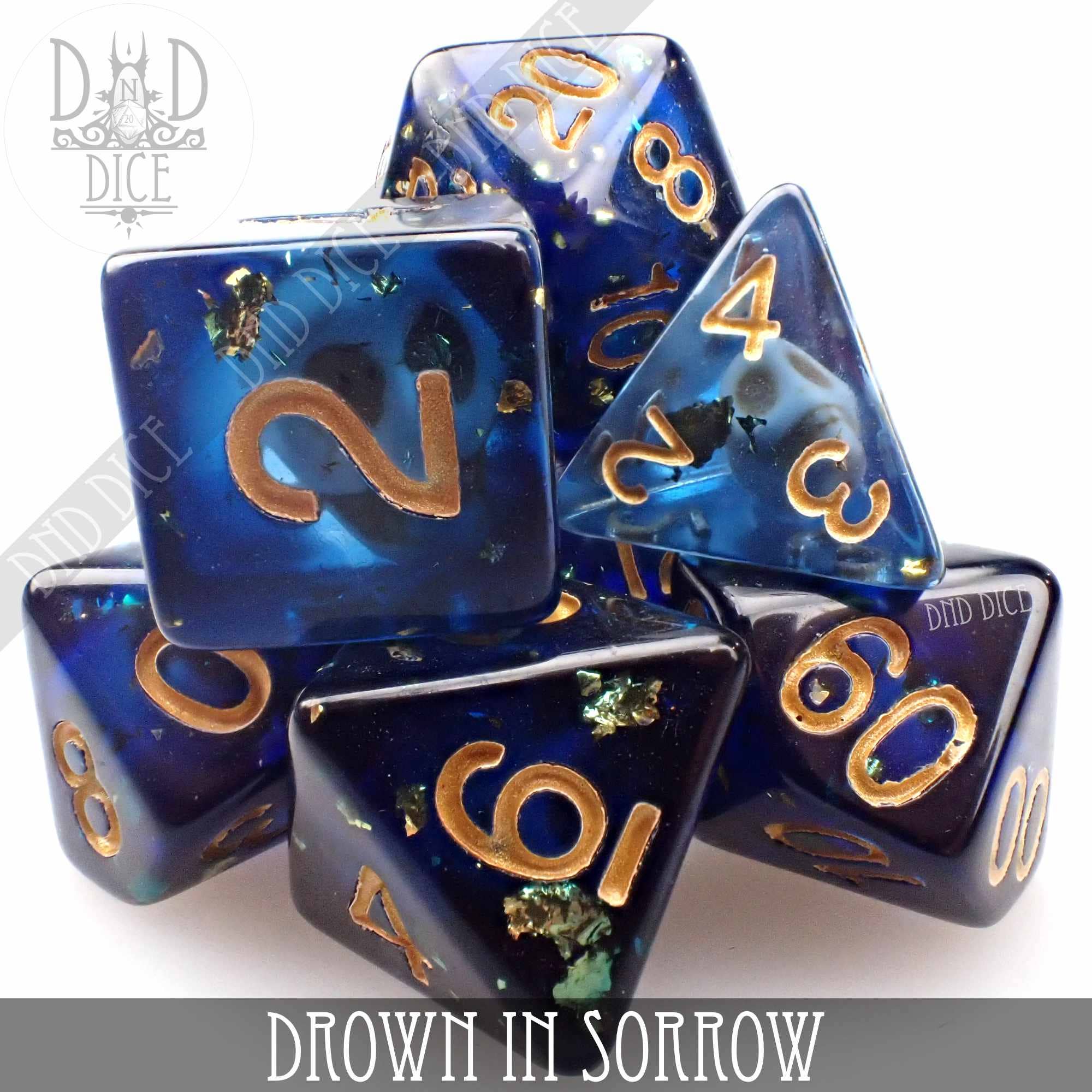 Drown in Sorrow blue resin dice set with gold numbers and green flecks.