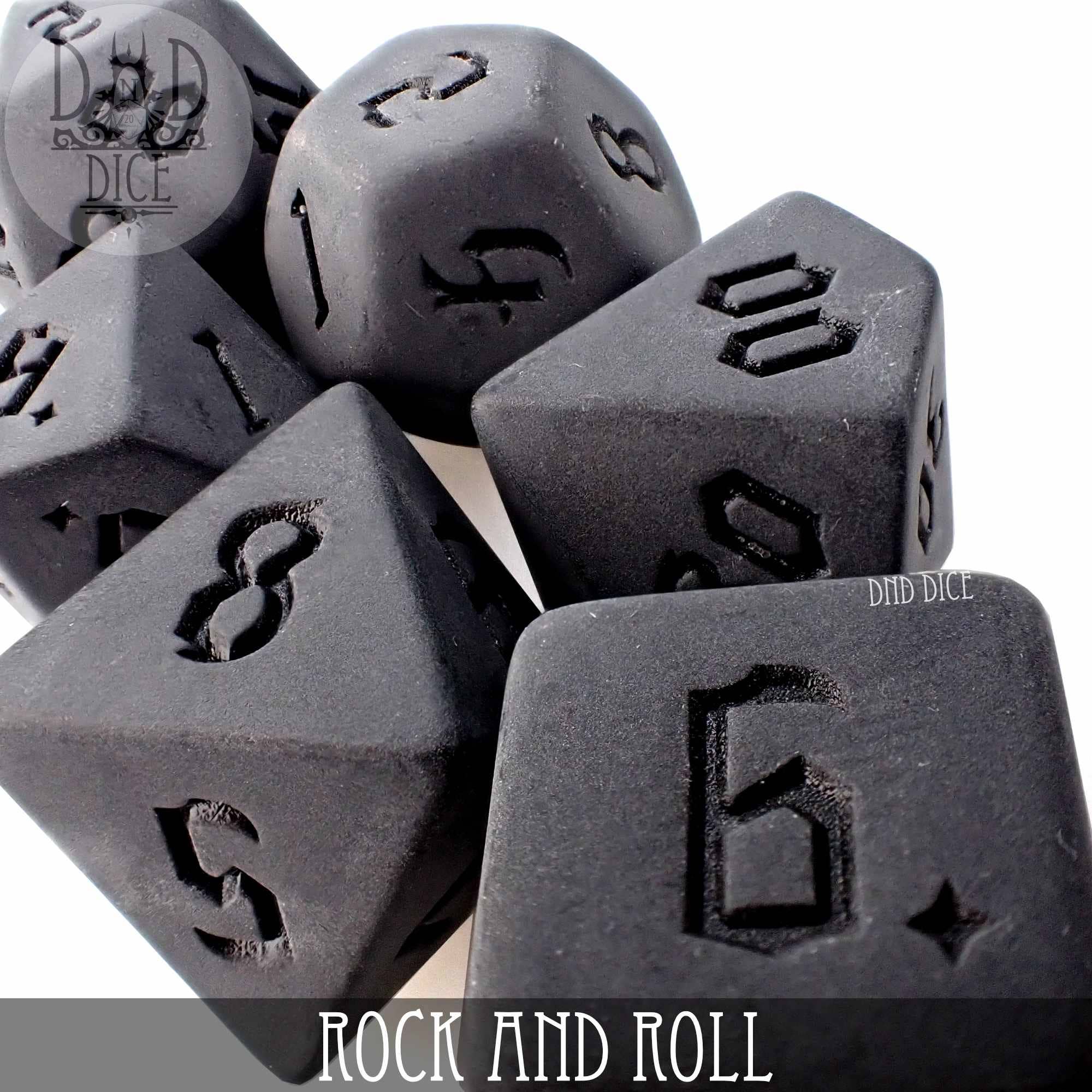 Rock and Roll 7-piece black acrylic dice set with engraved numbers for tabletop gaming.