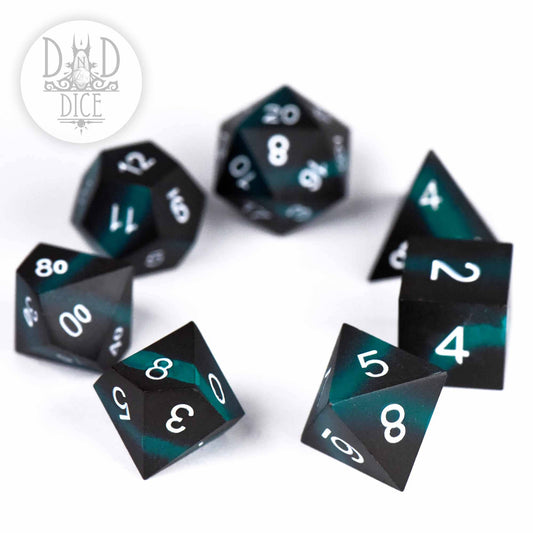Seven Tagging Teal metal DnD dice, black and teal with white numbers.