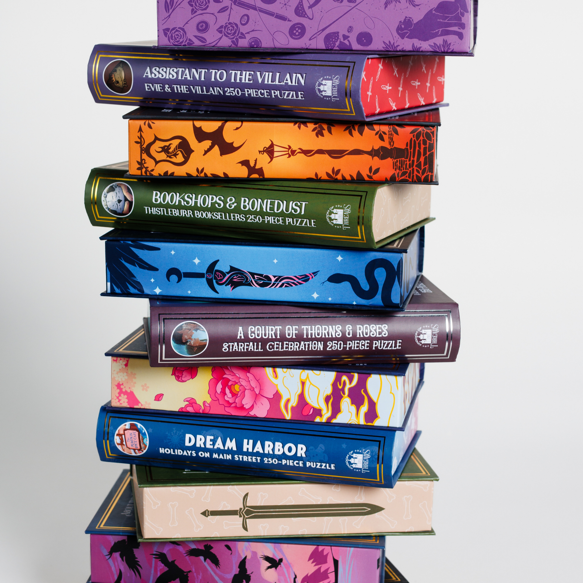 Say You’ll Return Keepsake Puzzle | Six of Crows stacked with other fantasy puzzle boxes showing illustrated spines.