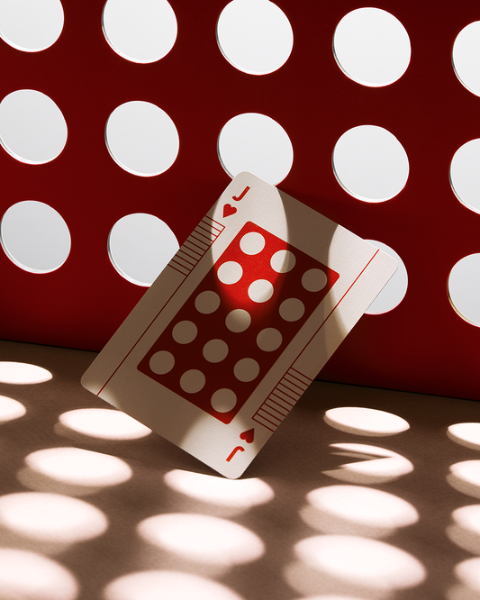 Eames The Little Toy Jack of Hearts playing card with red circular pattern on a matching red panel.
