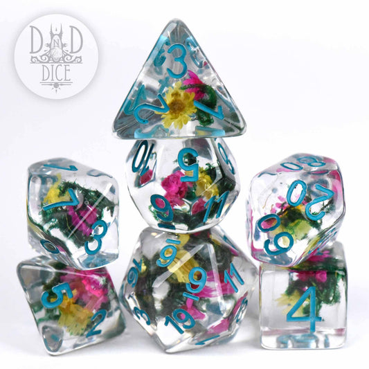 Vintage Bloom clear resin D&D dice set with embedded colorful flowers and blue numbers, stacked in a pyramid.