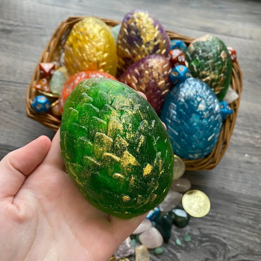 Pink Dragon Egg Dice Soap held in hand; assorted colorful vegan soap eggs with dice are in a basket in the background.