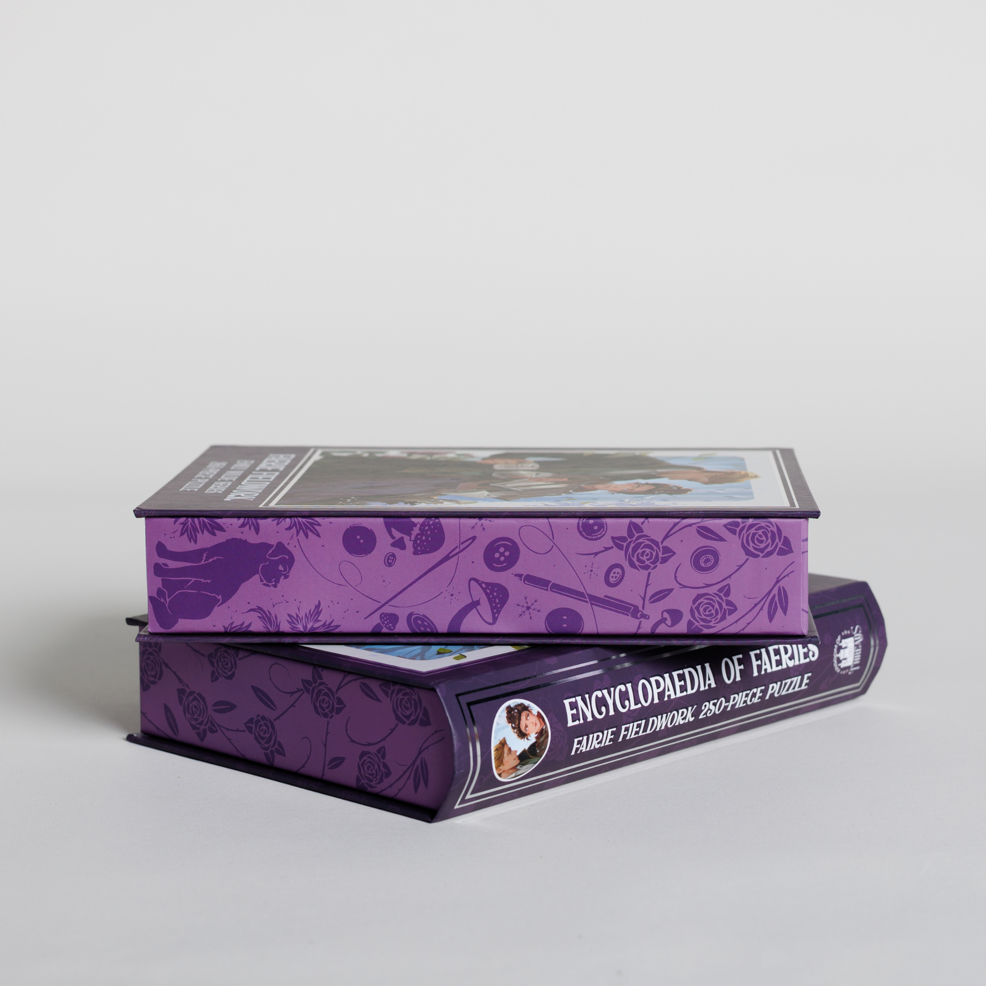 Two stacked purple Faerie Fieldwork Keepsake Puzzles featuring Emily Wilde branding.