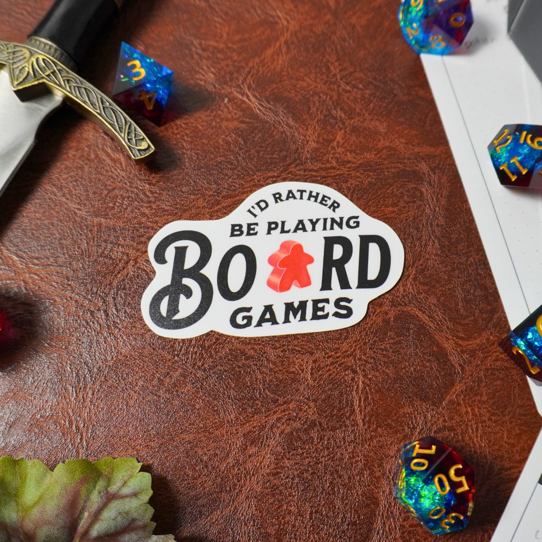 “I’d Rather Be Playing Board Games” sticker with dice and a sword.