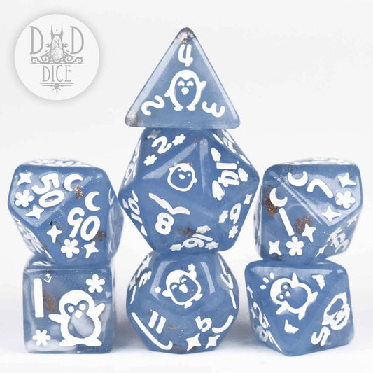 Penguin Plunge set of 7 blue resin dice featuring white penguins and snowflakes.