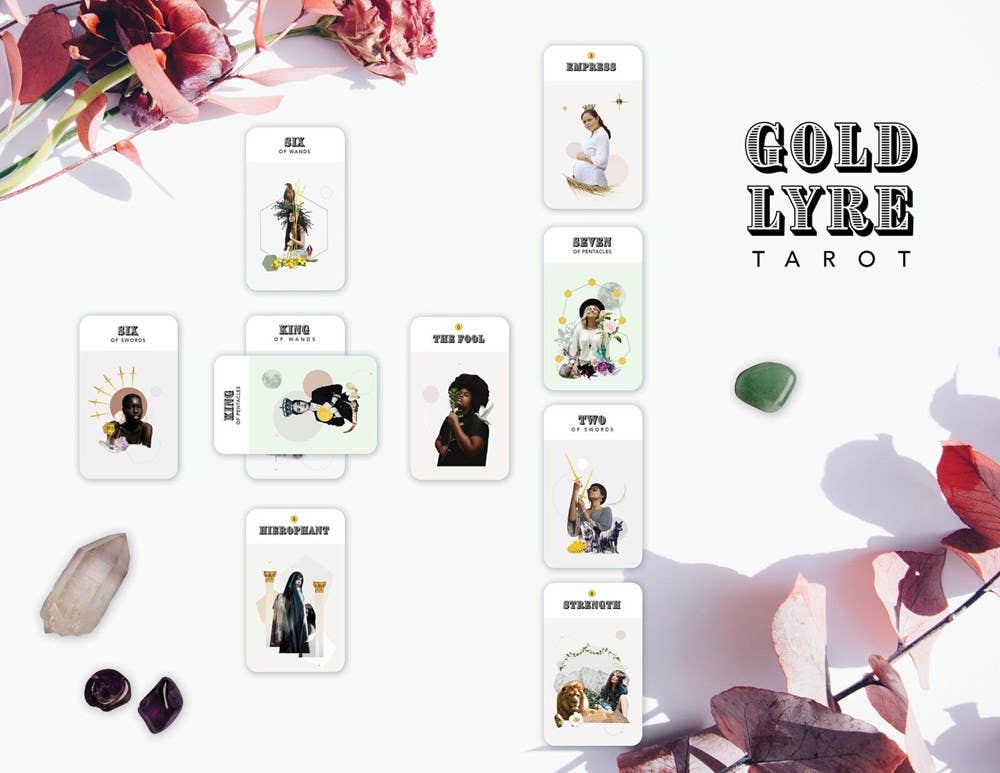 Gold Lyre Tarot deck displayed on a white surface, with crystals and dried leaves nearby.