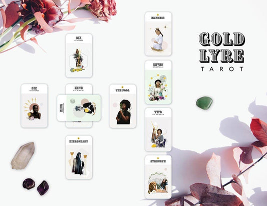 Gold Lyre Tarot deck displayed on a white surface, with crystals and dried leaves nearby.